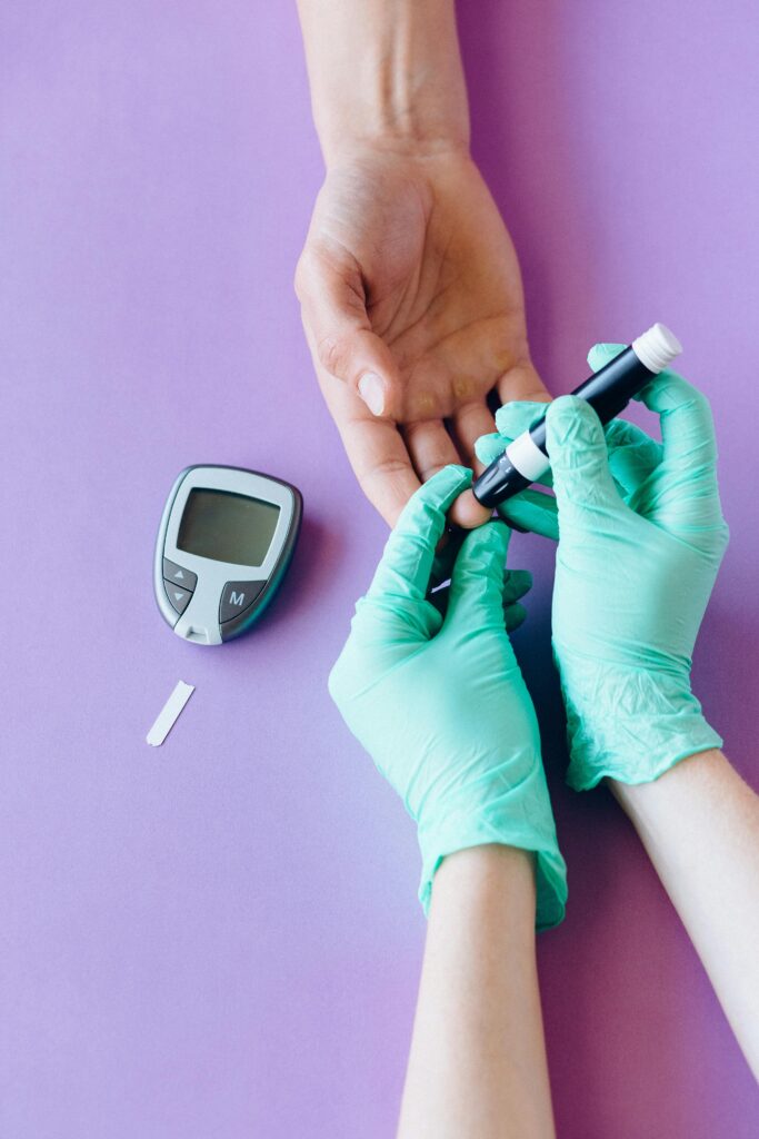 pexels-photo-6941103-6941103 A healthcare worker uses a glucose meter to check a patient's blood sugar level.