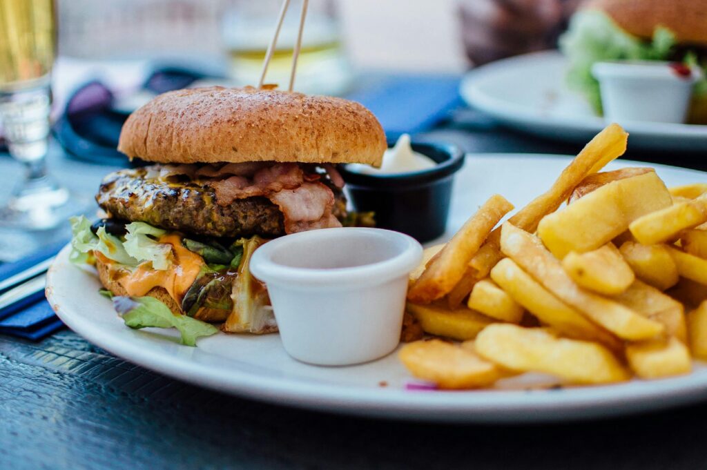 pexels-photo-70497-70497 Close-up of a juicy burger and crispy fries served with sauces, perfect for a hearty meal.