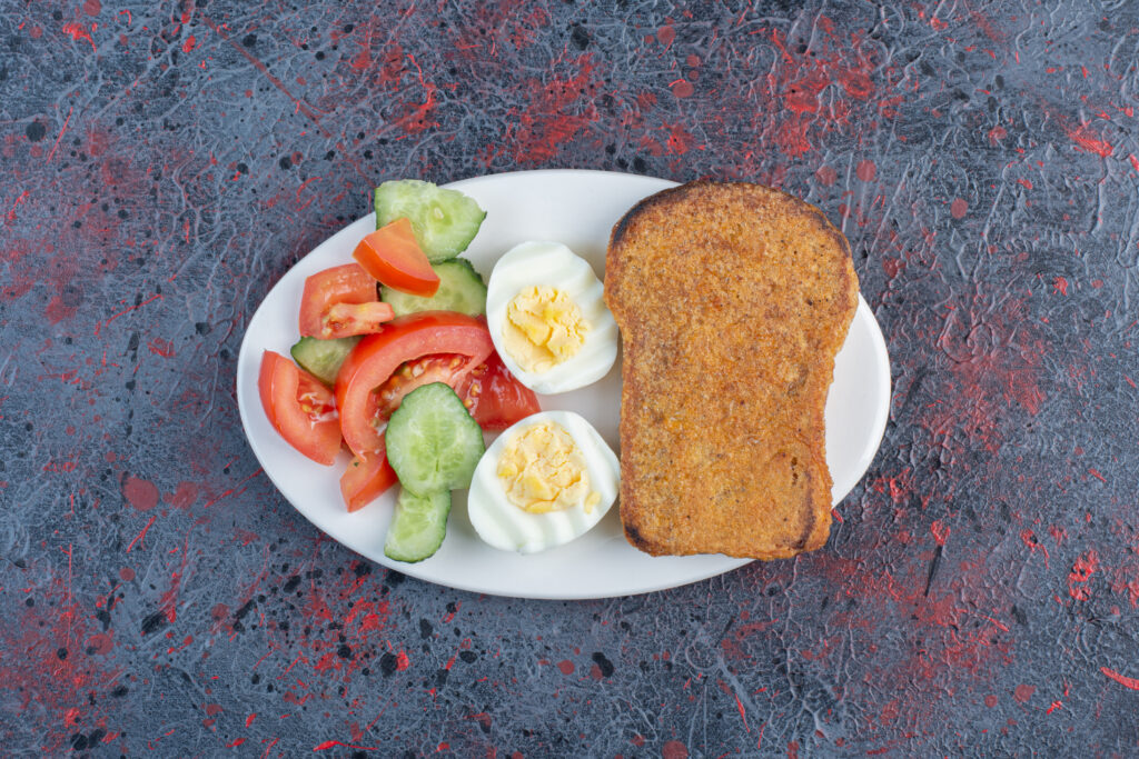Breakfast plate with egg, cucumber, tomato and bread slices The Ultimate Guide to 1500 Calorie Diet for Natural Blood Sugar Control: A Comprehensive Approach for India and USA.